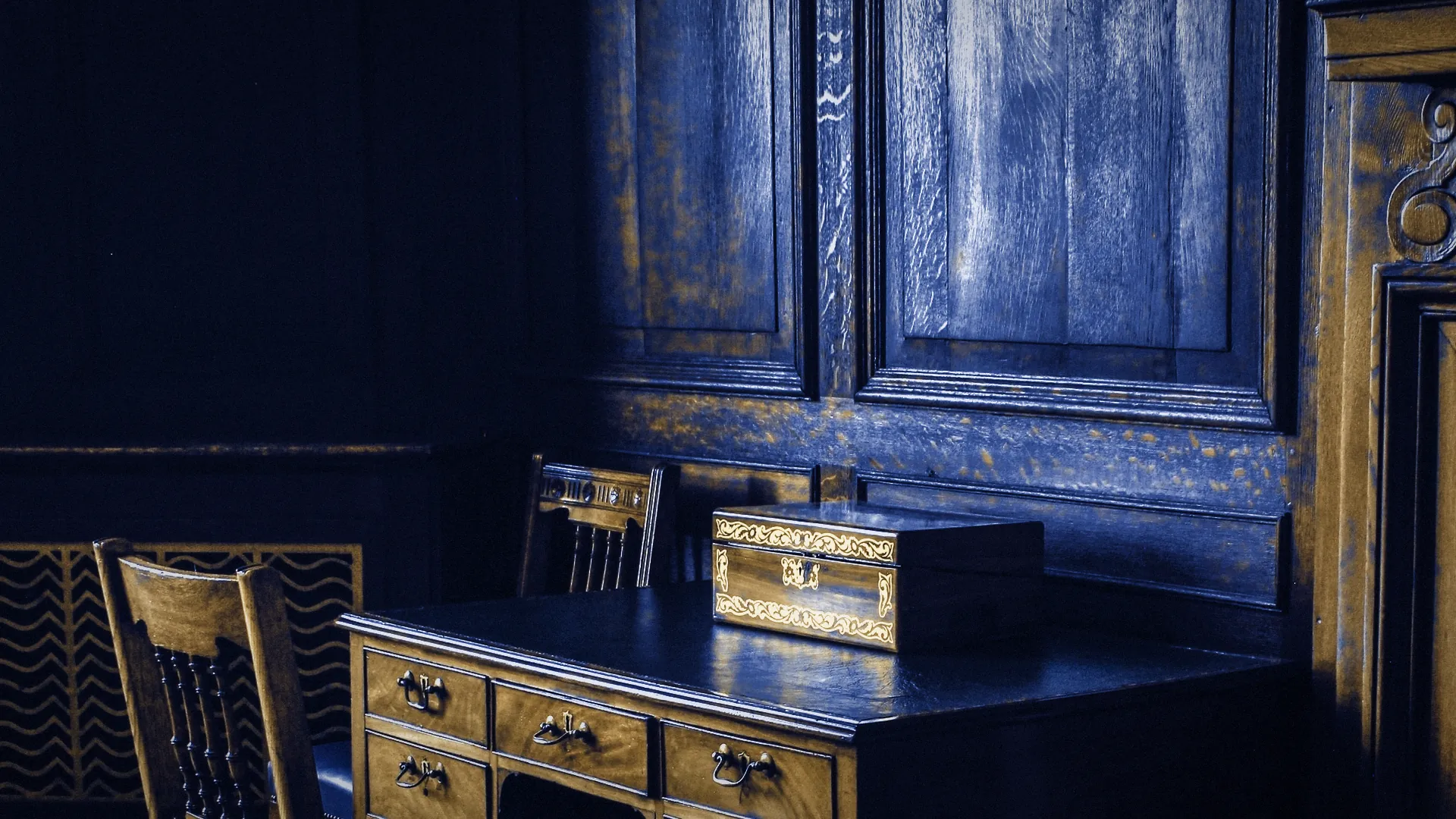 A wood-panelled study with a writing desk